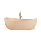 Hawaii freestanding concrete bathtub with wave-inspired design shown from front angle in a soft pastel orange shade known as Peach.